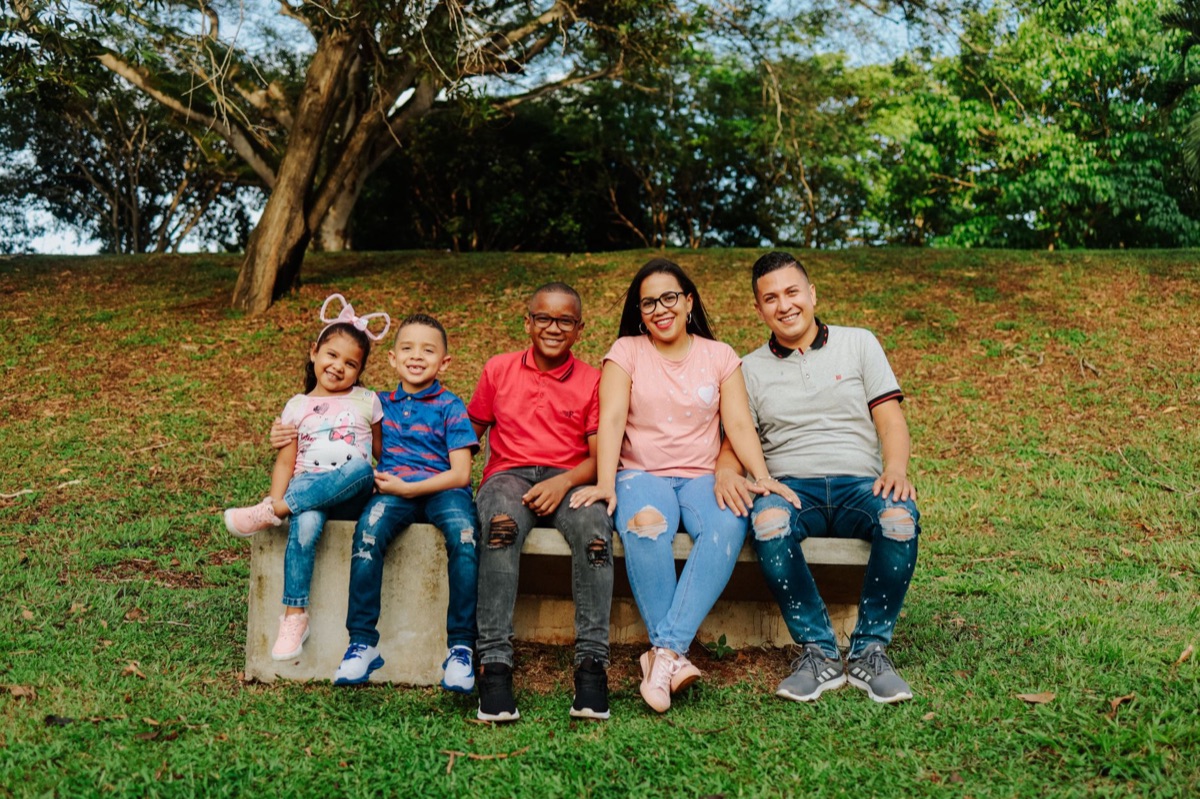 Família italiana sentada em uma bancada de parque