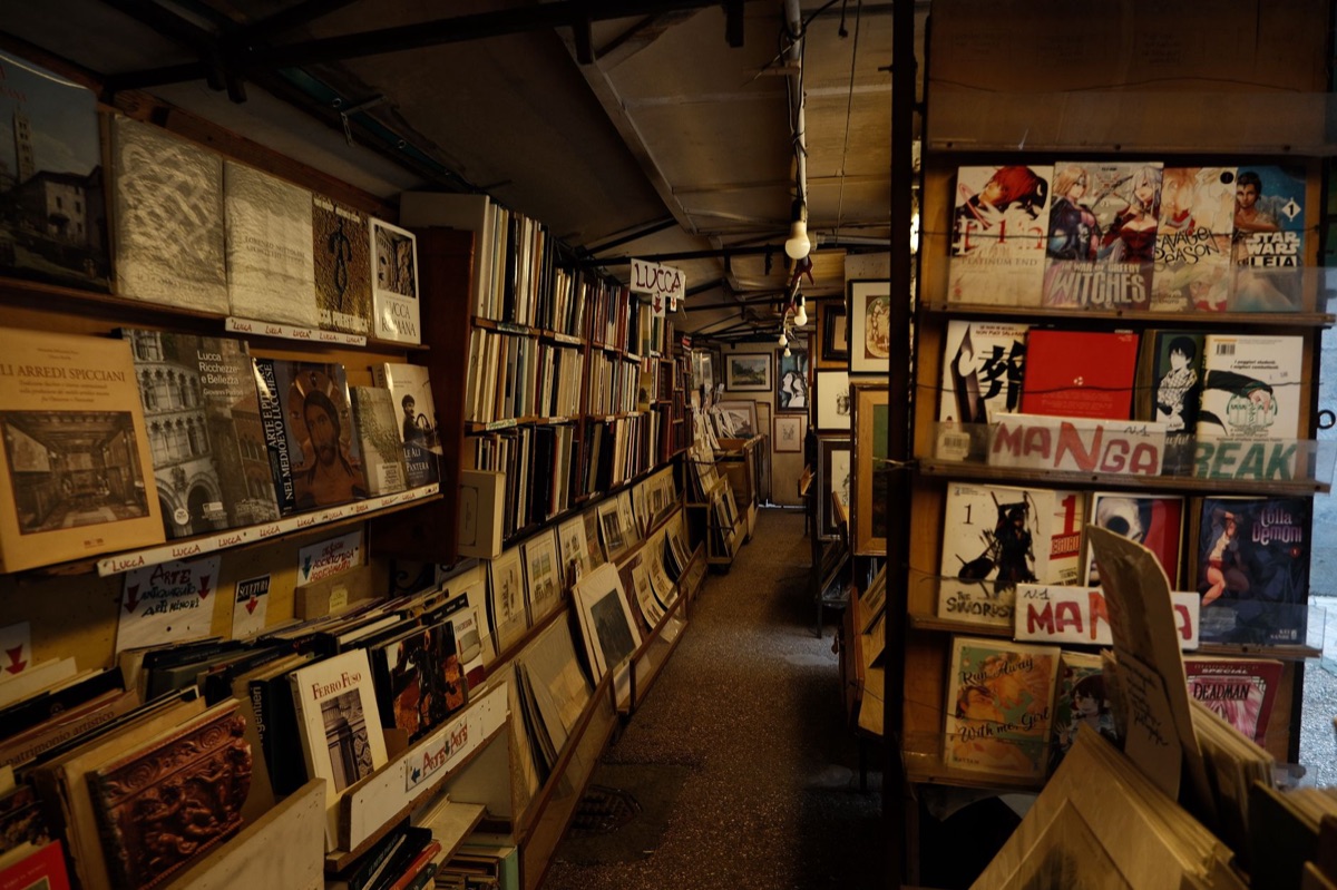 Ventana de una tienda de cómics italiana con libros de cómics en la vitrina.