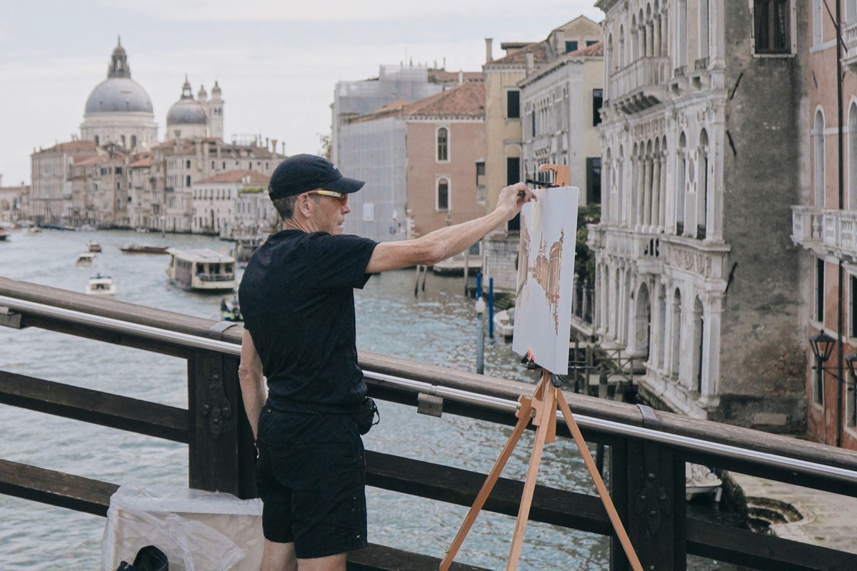 Un artista italiano trabajando en un estudio con papeles de cómic y herramientas de dibujo.