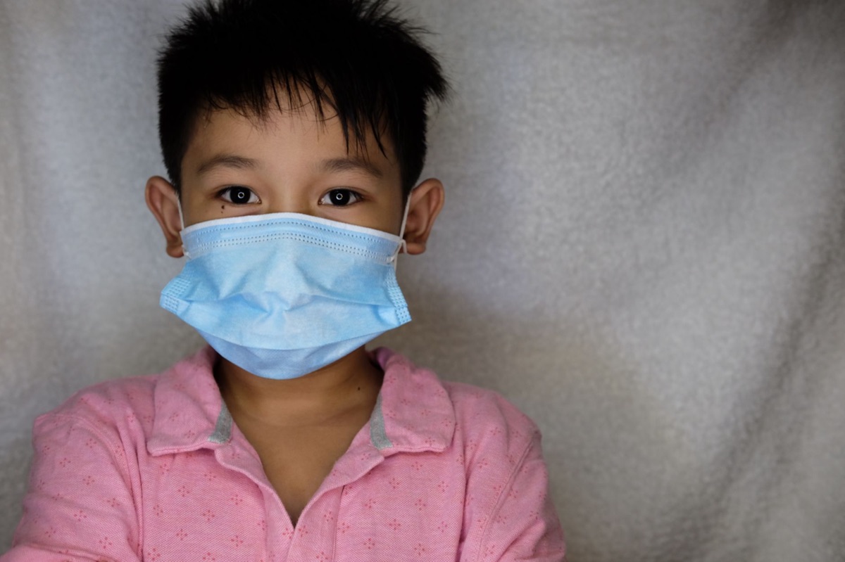 Italian child wearing medical mask in public space