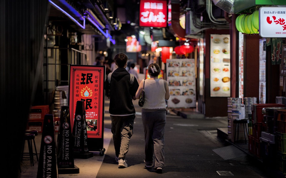 Menschen zeigen auf asiatisches Restaurant-Schild in italienischer Straße